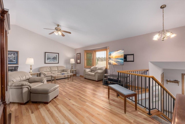 living area with light wood-style floors, lofted ceiling, and ceiling fan with notable chandelier