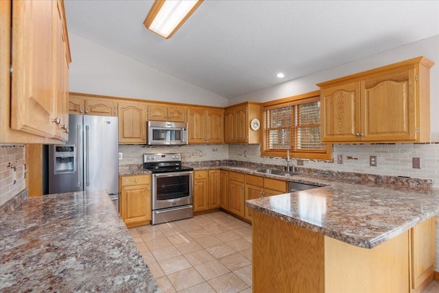 kitchen with tasteful backsplash, a peninsula, vaulted ceiling, stainless steel appliances, and a sink