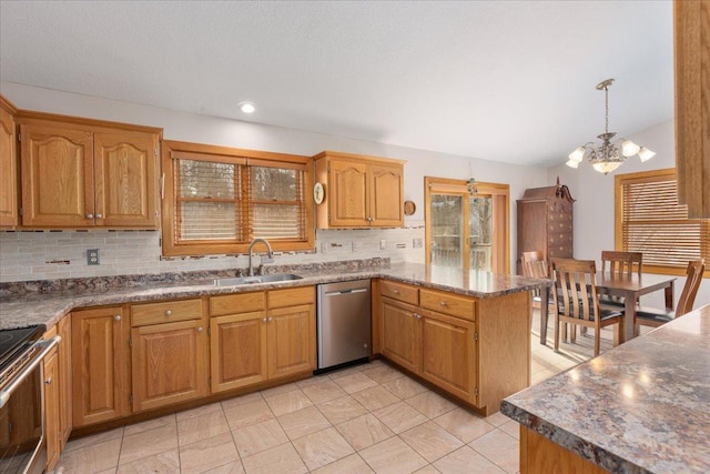 kitchen featuring decorative backsplash, appliances with stainless steel finishes, vaulted ceiling, a sink, and a peninsula