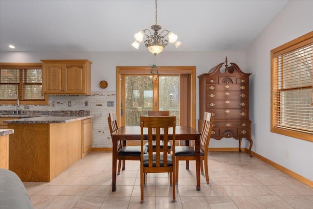 dining space with light tile patterned floors, baseboards, and a notable chandelier