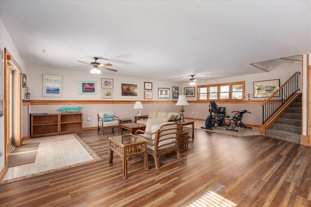 living area with stairs, ceiling fan, wood finished floors, and baseboards