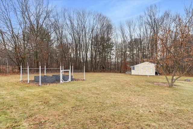 view of yard with a shed, a vegetable garden, and an outbuilding