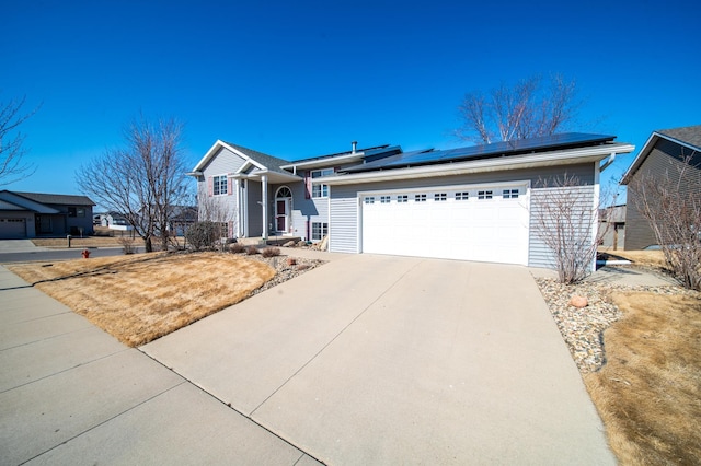 single story home featuring driveway, a garage, and solar panels