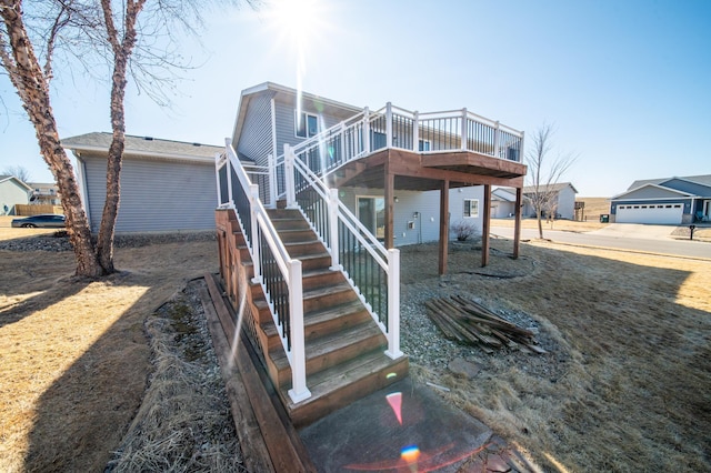 rear view of house with stairs and a wooden deck