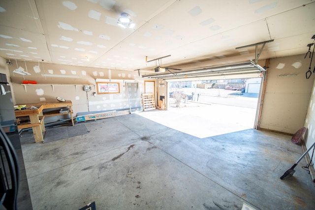 garage with a workshop area and a garage door opener