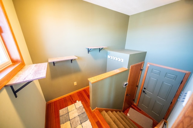 stairway featuring wood finished floors and baseboards