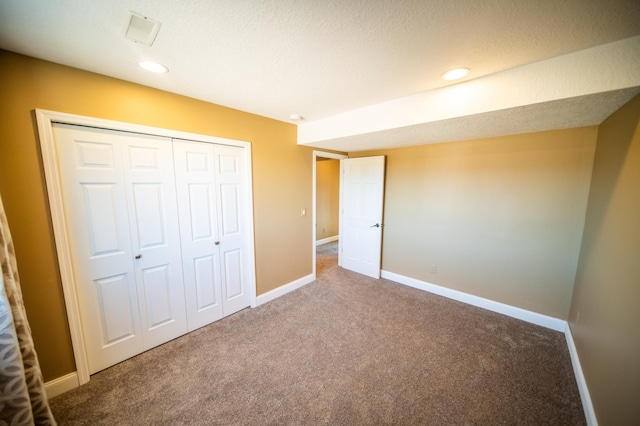 unfurnished bedroom with carpet floors, a closet, and baseboards