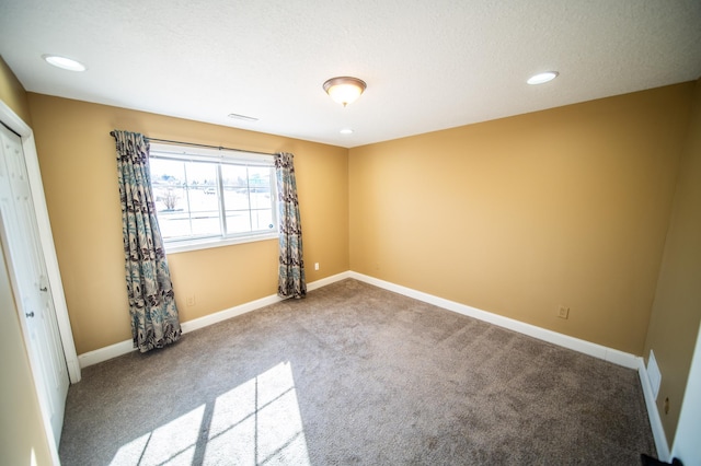 spare room featuring recessed lighting, visible vents, carpet flooring, a textured ceiling, and baseboards