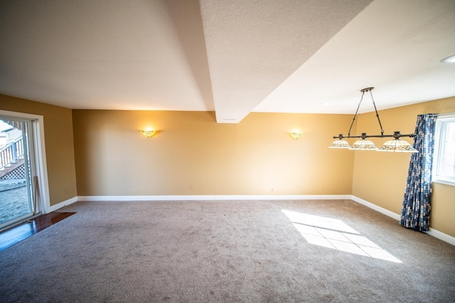 carpeted spare room featuring baseboards