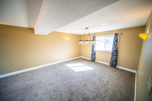 carpeted spare room featuring baseboards