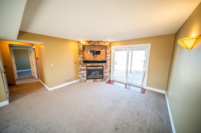 unfurnished living room featuring carpet, a fireplace, and baseboards