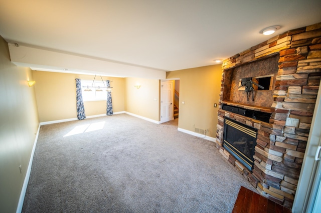 unfurnished living room featuring visible vents, baseboards, carpet flooring, and a stone fireplace