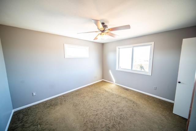 spare room featuring ceiling fan, carpet floors, visible vents, and baseboards