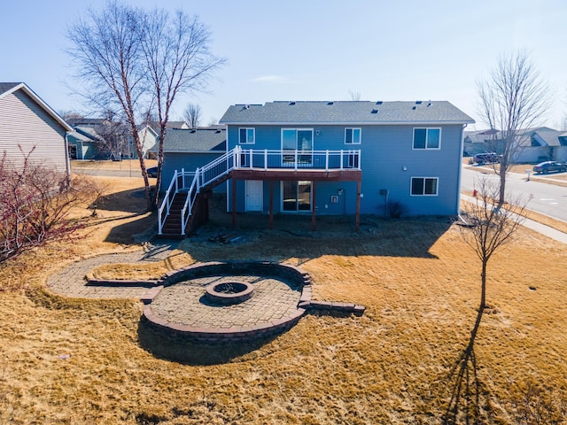 rear view of house featuring a deck, stairway, and a fire pit