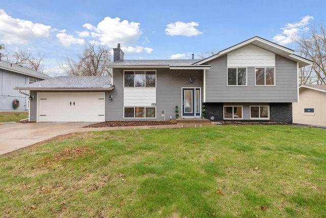 raised ranch featuring a garage, a chimney, driveway, and a front yard