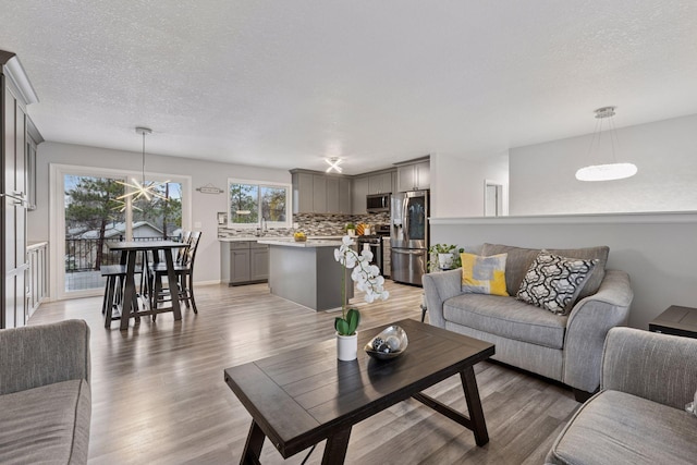 living area featuring light wood-type flooring and a textured ceiling