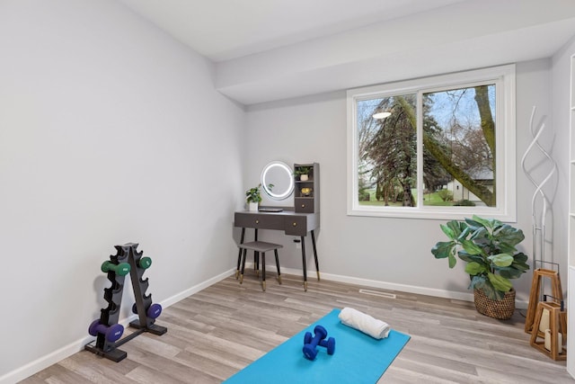 workout room featuring baseboards and wood finished floors