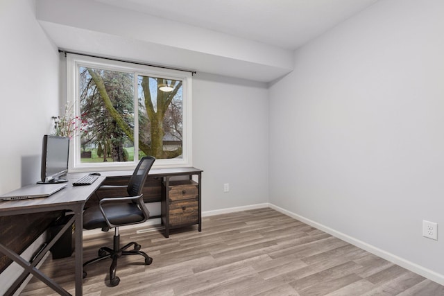 office area with baseboards and light wood-type flooring