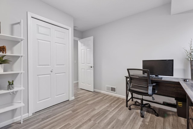 office with baseboards, visible vents, and light wood-type flooring