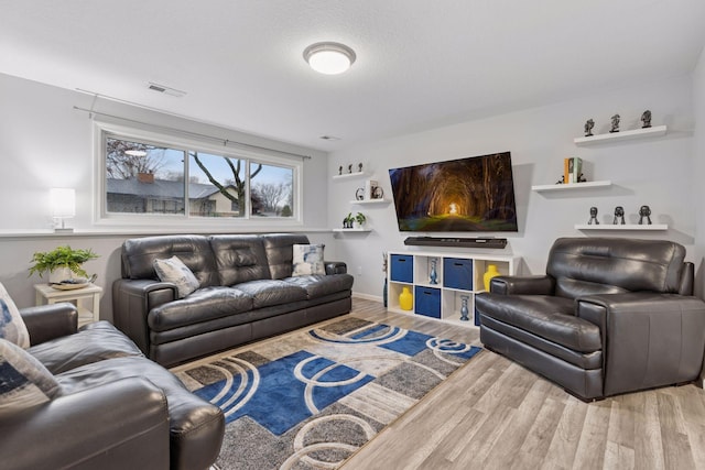 living area featuring wood finished floors and visible vents