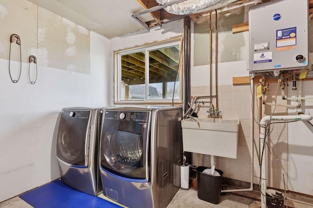 laundry area featuring laundry area, a sink, water heater, and washer and dryer