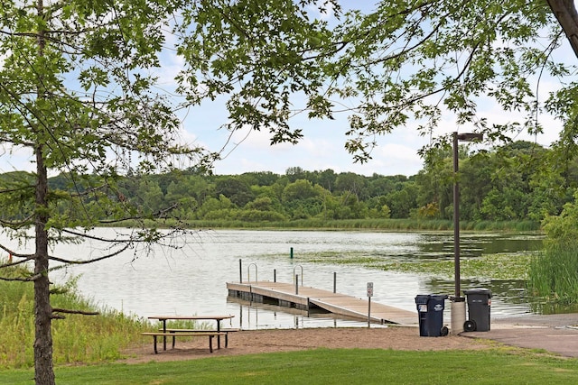 view of dock with a water view and a wooded view