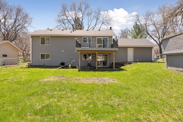 rear view of house featuring a lawn and a wooden deck