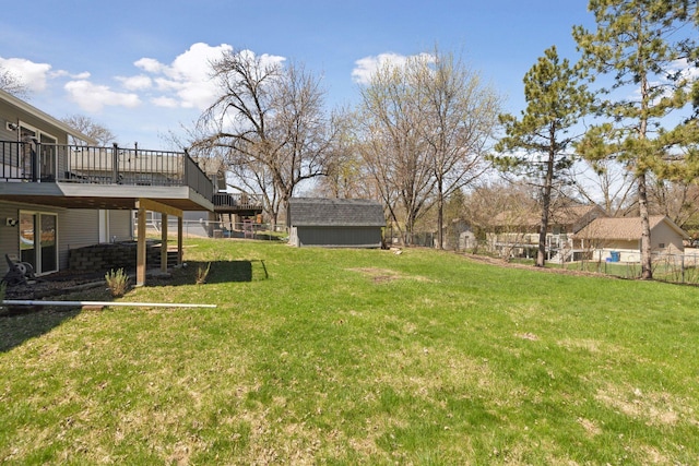 view of yard with an outdoor structure, a deck, fence, and a shed