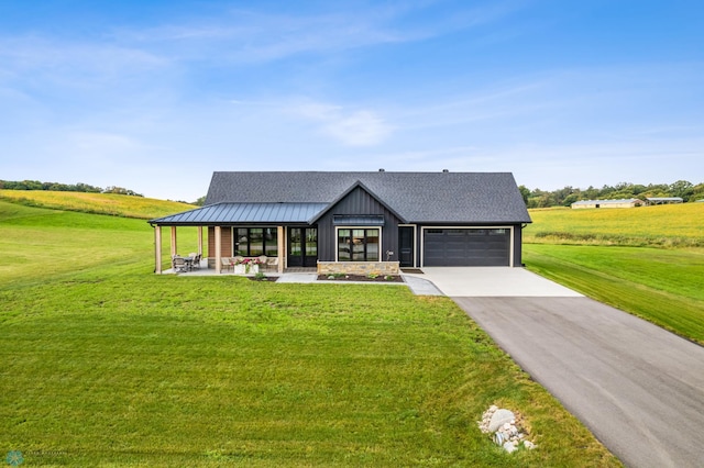 modern inspired farmhouse with a garage, a front lawn, roof with shingles, and a standing seam roof