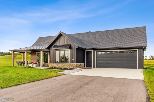 view of front of property with driveway, a garage, metal roof, a standing seam roof, and a front lawn