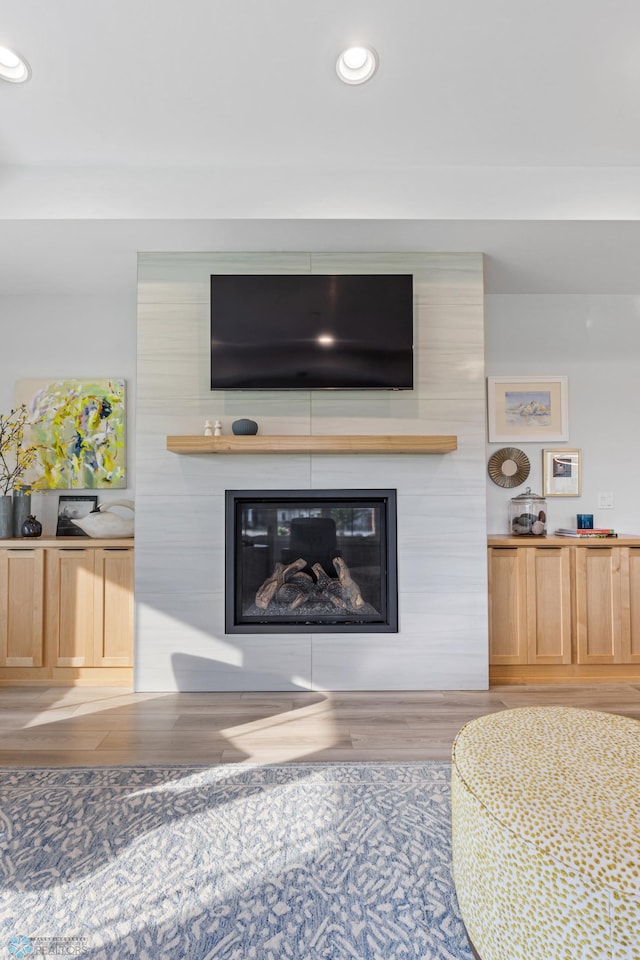 details featuring a fireplace, wood finished floors, and recessed lighting