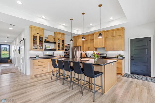 kitchen featuring light brown cabinetry, appliances with stainless steel finishes, and dark countertops