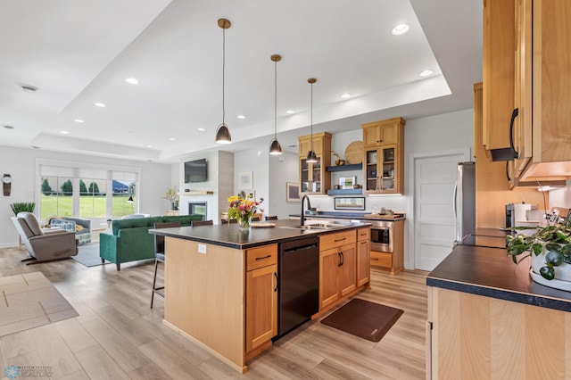 kitchen with dishwasher, a sink, dark countertops, and a raised ceiling