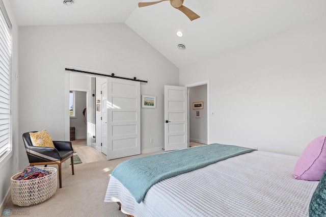 bedroom with a barn door, visible vents, a ceiling fan, light colored carpet, and high vaulted ceiling