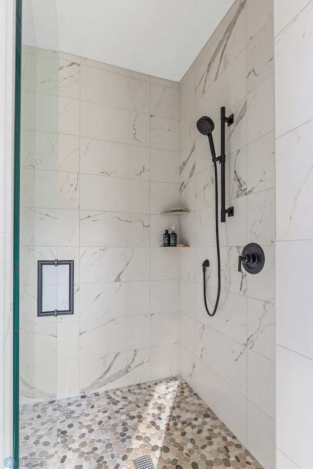 full bath with a tile shower