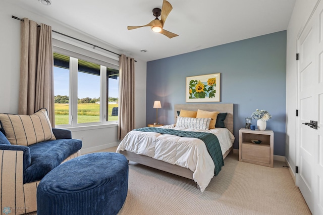 bedroom featuring a ceiling fan, light colored carpet, and baseboards