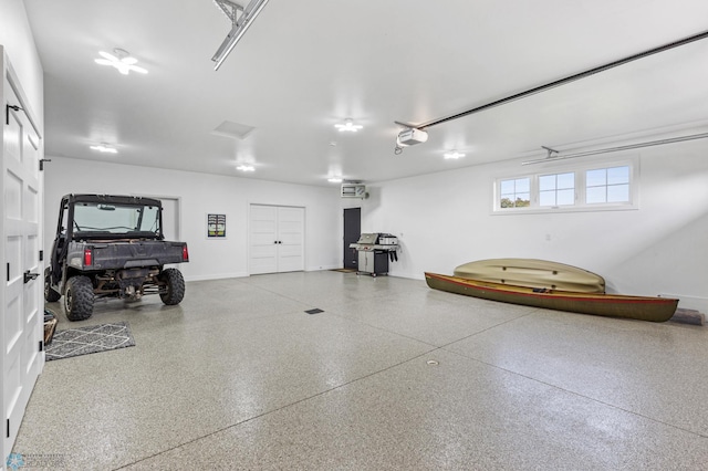 garage featuring a garage door opener and baseboards