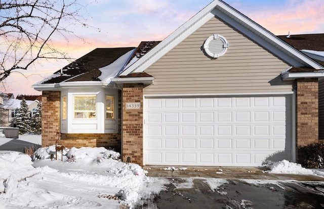 ranch-style house featuring an attached garage and brick siding