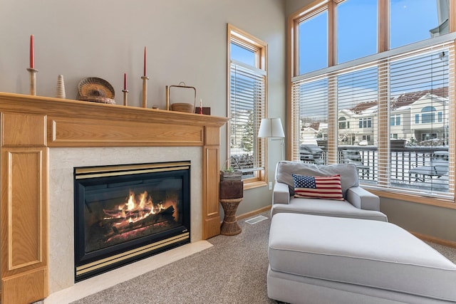 living area with carpet, a healthy amount of sunlight, visible vents, and a fireplace