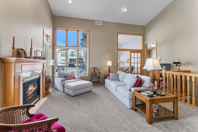 carpeted living room with a glass covered fireplace, visible vents, and recessed lighting