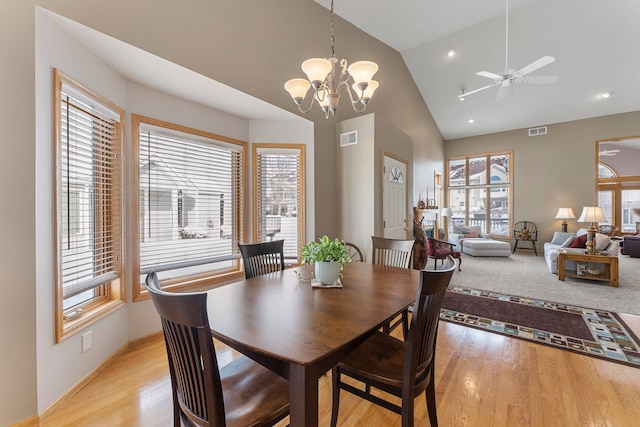 dining room featuring vaulted ceiling, light wood-style flooring, and visible vents