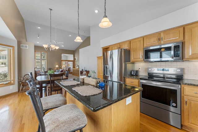 kitchen featuring a breakfast bar area, stainless steel appliances, visible vents, light wood-style floors, and a kitchen island