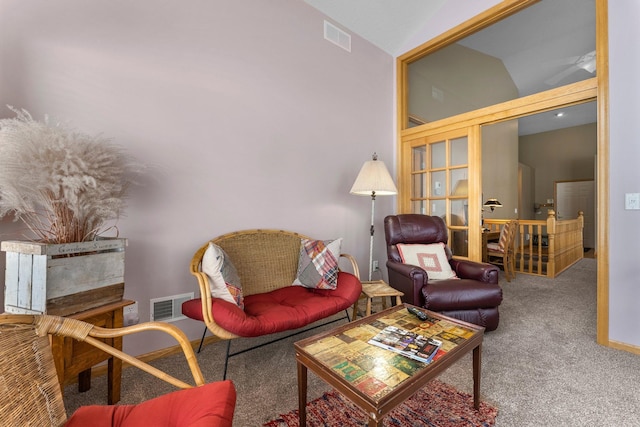 sitting room featuring lofted ceiling, baseboards, visible vents, and carpet flooring