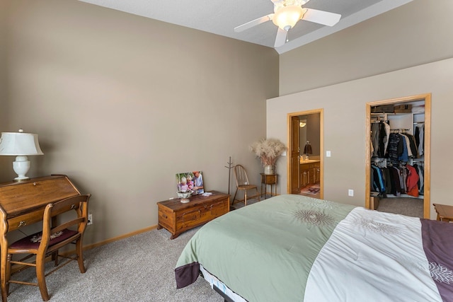 carpeted bedroom with a closet, a spacious closet, a ceiling fan, vaulted ceiling, and baseboards