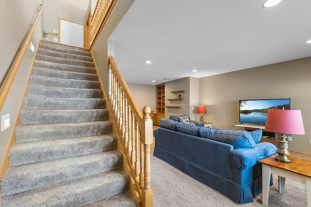 stairs with a textured ceiling, carpet floors, and recessed lighting