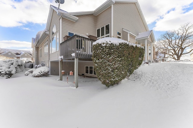 snow covered property with a deck