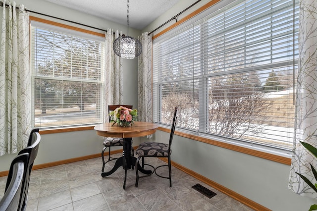 dining area with visible vents, a healthy amount of sunlight, and a textured ceiling