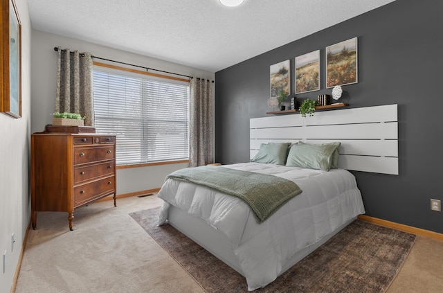 carpeted bedroom featuring baseboards and a textured ceiling