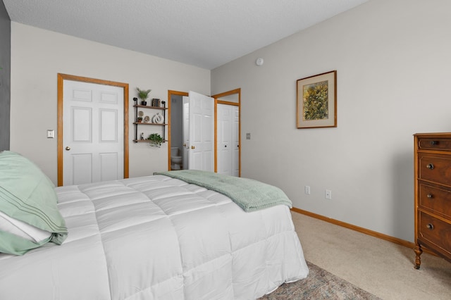 bedroom with baseboards, a textured ceiling, and carpet flooring