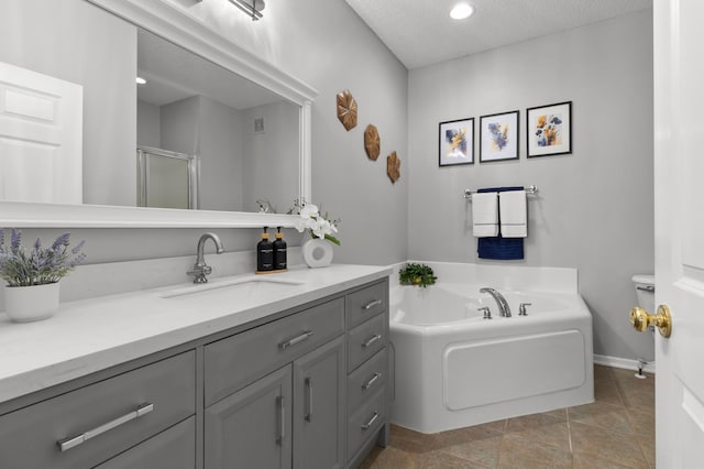 full bath with a garden tub, a stall shower, a textured ceiling, tile patterned flooring, and vanity